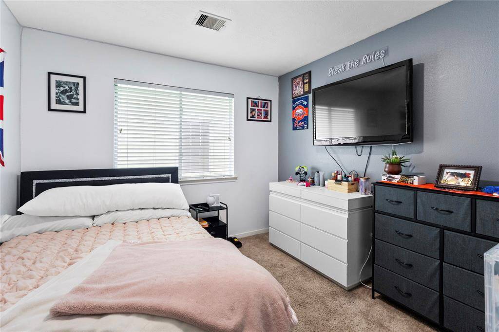 Cozy and inviting second bedroom with ample natural light and modern decor, perfect for relaxation or guests.