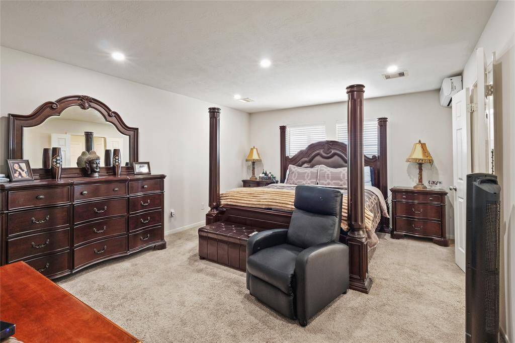 Spacious primary bedroom soft carpeting, and ample natural light for a cozy retreat.