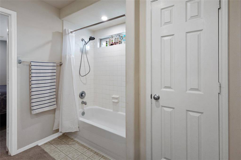 Inviting primary bathroom featuring a classic tub-shower combo, ample storage, and a bright, clean design. Perfect for relaxation and functionality.