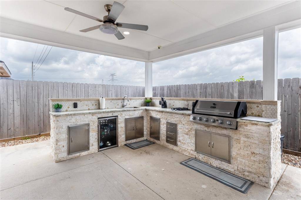 Sleek outdoor kitchen featuring a propane grill, sink, and mini fridge—perfect for entertaining.