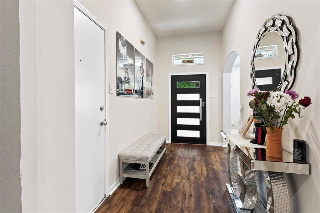 Welcoming foyer featuring elegant wood flooring, abundant natural light, and stylish decor—perfect for making a lasting first impression.