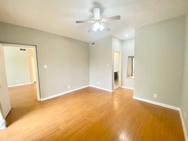 View of primary bedroom with left side door going into the living room and right side has en-suite bath and walk in closet.