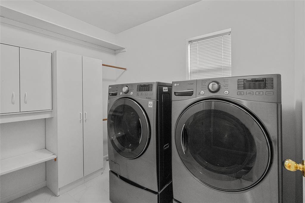 Spacious utility with cabinets and shelving