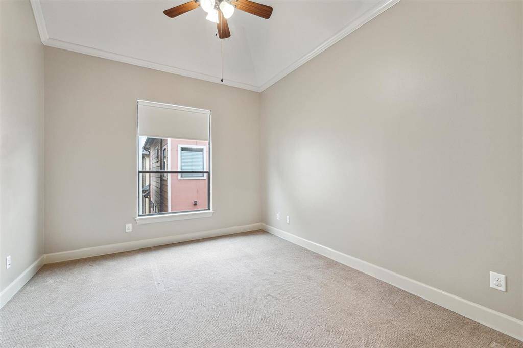 Secondary bedroom with crown molding, large window, and walk-in closet.