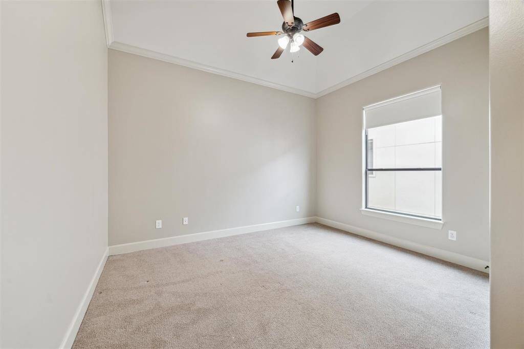 Another secondary bedroom with crown molding, large window, and walk-in closet.