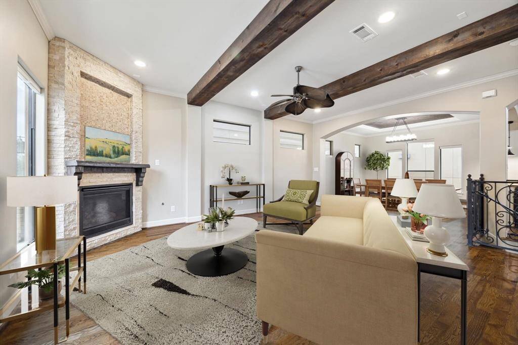 Family room showcasing exposed wood beams, a mosaic tile and stone gas log fireplace, creating a warm and elegant focal point perfect for relaxing and entertaining.
