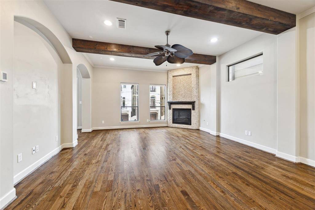 Spacious living area with gleaming wood floors, high ceilings, and a warm, inviting ambiance.