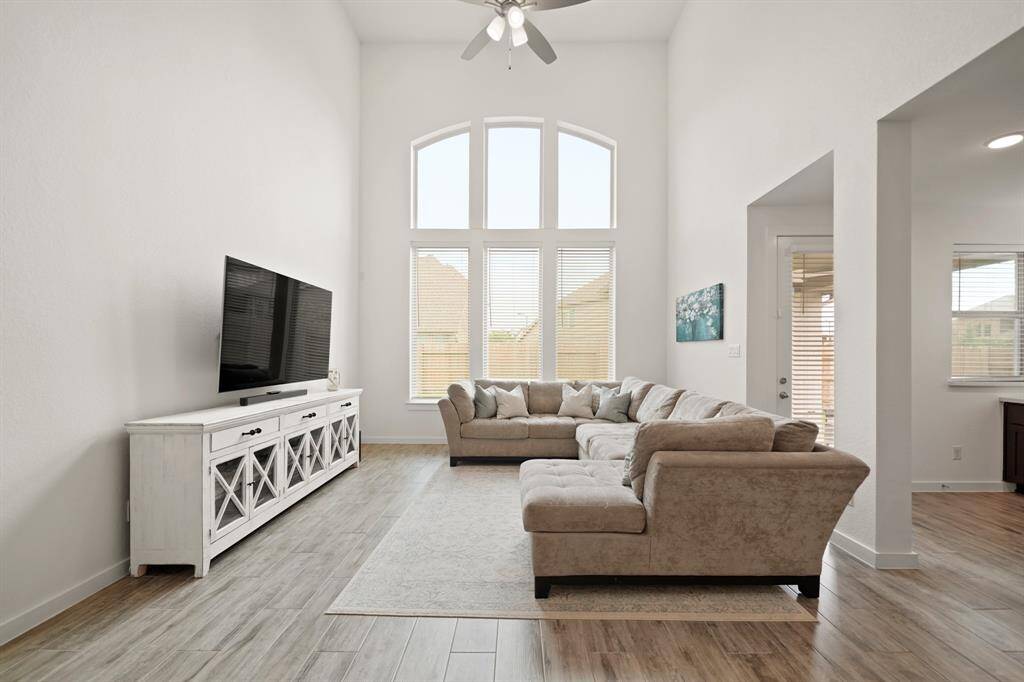Large windows with blinds overlook the backyard and fill this living space with plenty of natural light.