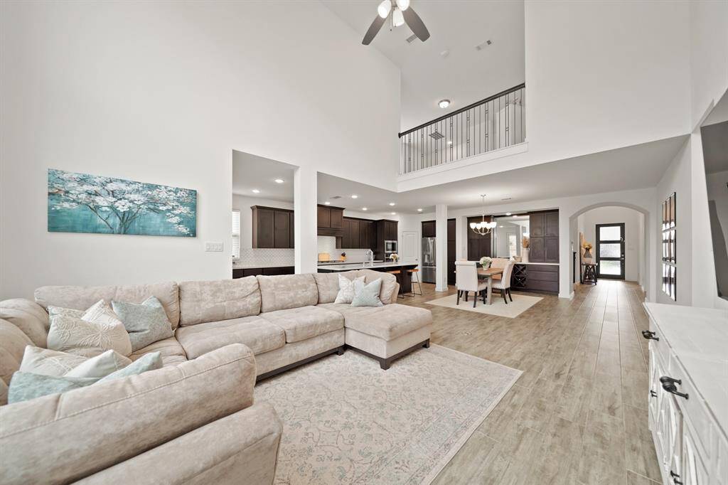 A view of the kitchen, dining room & foyer from the living room. Don't miss the wood-stained & wrought iron balcony from the second level of the home.