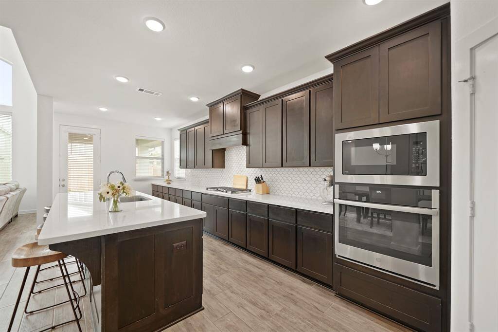 The GE stainless steel appliance package includes a 5-burner gas cook top, built-in microwave & conventional ovens and a dishwasher.