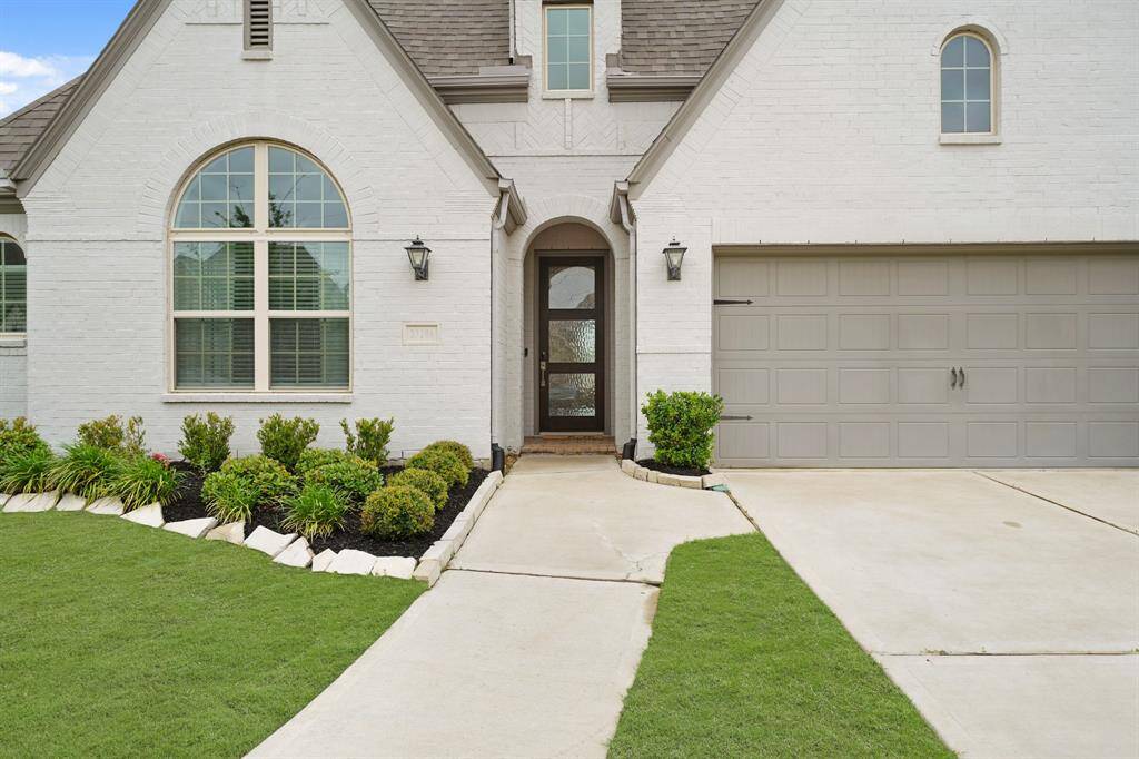Welcome your family & friends to your new home on the arched & covered front porch complete with brick flooring, video door bell and coach lantern lighting. A paved walkway leads to the double-wide driveway with access to the home's two-car attached garage.