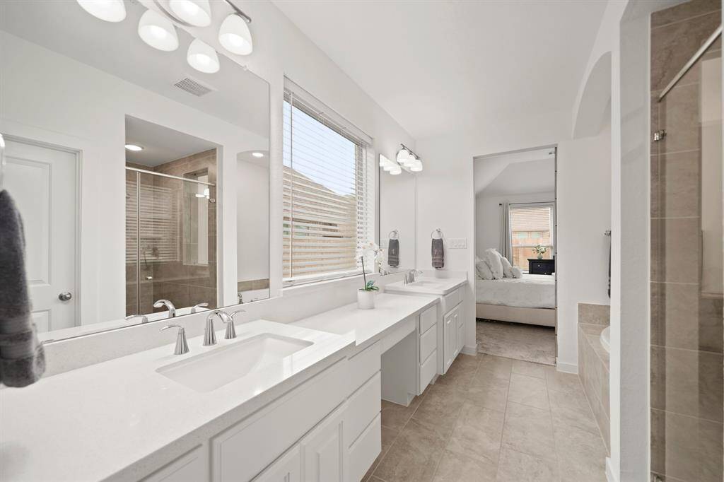 Additional features include a window with blinds sitting just above the make-up vanity, private water closet, spacious walk-in storage closet & tile flooring. A linen storage closet is accessible in the vestibule leading to this owner's suite.