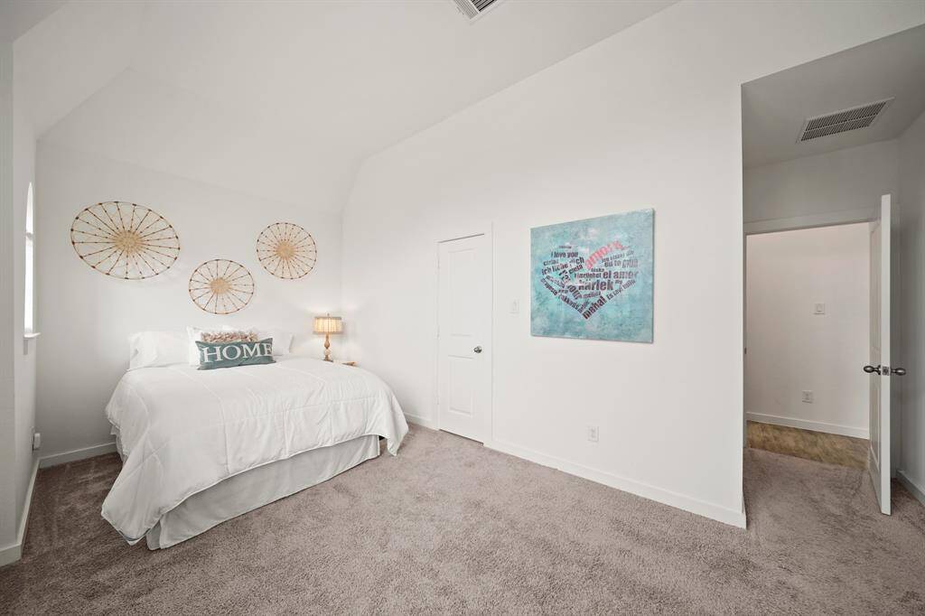 Situated on the front of the home with arched windows & blinds, this secondary bedroom is perfect as a guest or Mother-in-Law suite. Features include a high ceiling with a ceiling mounted light fixture, walk-in wardrobe closet & carpet.