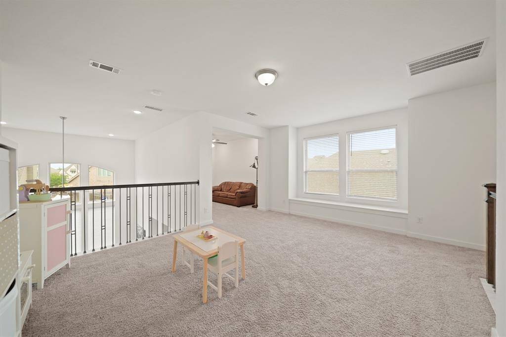 Large windows with blinds and a window seat sit just between the game & media rooms.