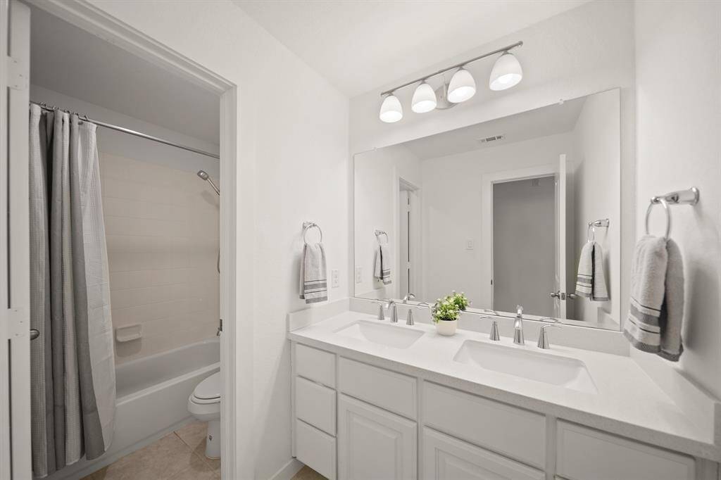 Positioned between the third & fourth bedrooms is the home's third full bath. Features included painted cabinets with a quartz counter top highlighted by wall mounted mirror & lighting, a private water closet with a ceramic tile surrounded combination tub/shower & tile flooring.