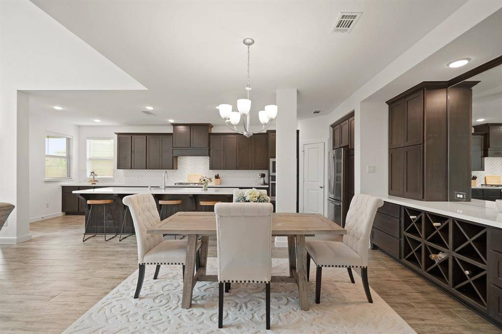 The formal dining room illuminated by chandelier lighting sits near the kitchen and is adjacent to the living room.