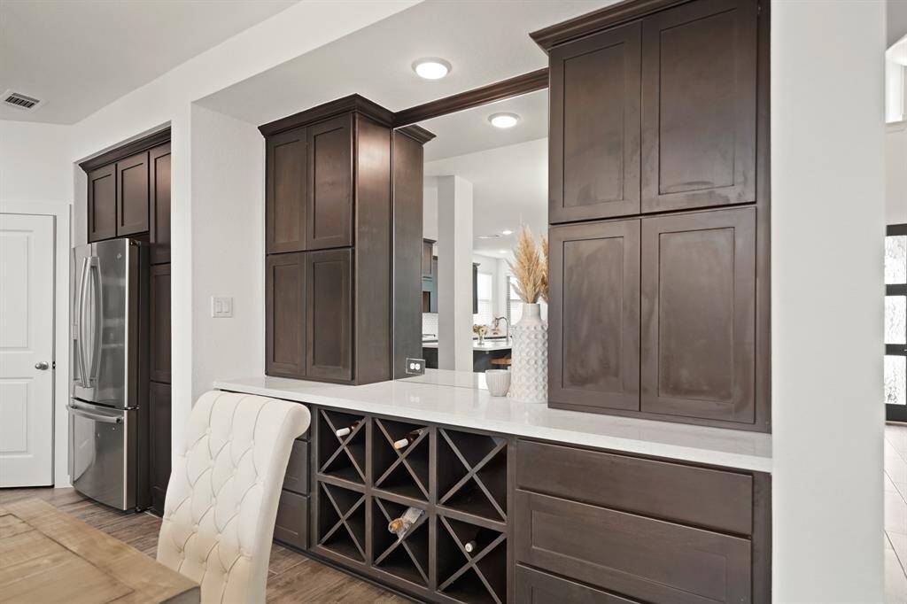 A custom recessed butler's pantry with upper shelf storage and a quartz serving counter includes drawer and wine bottle storage below.