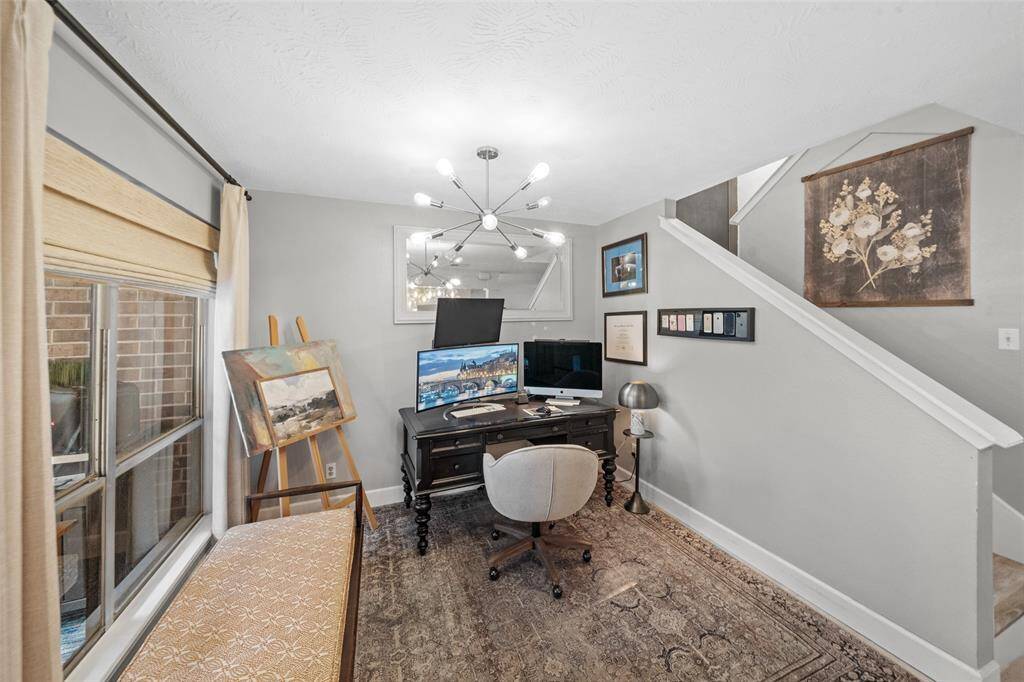 This cozy home office features, ample natural light from a large window,  It's an inviting space for productivity and creativity.