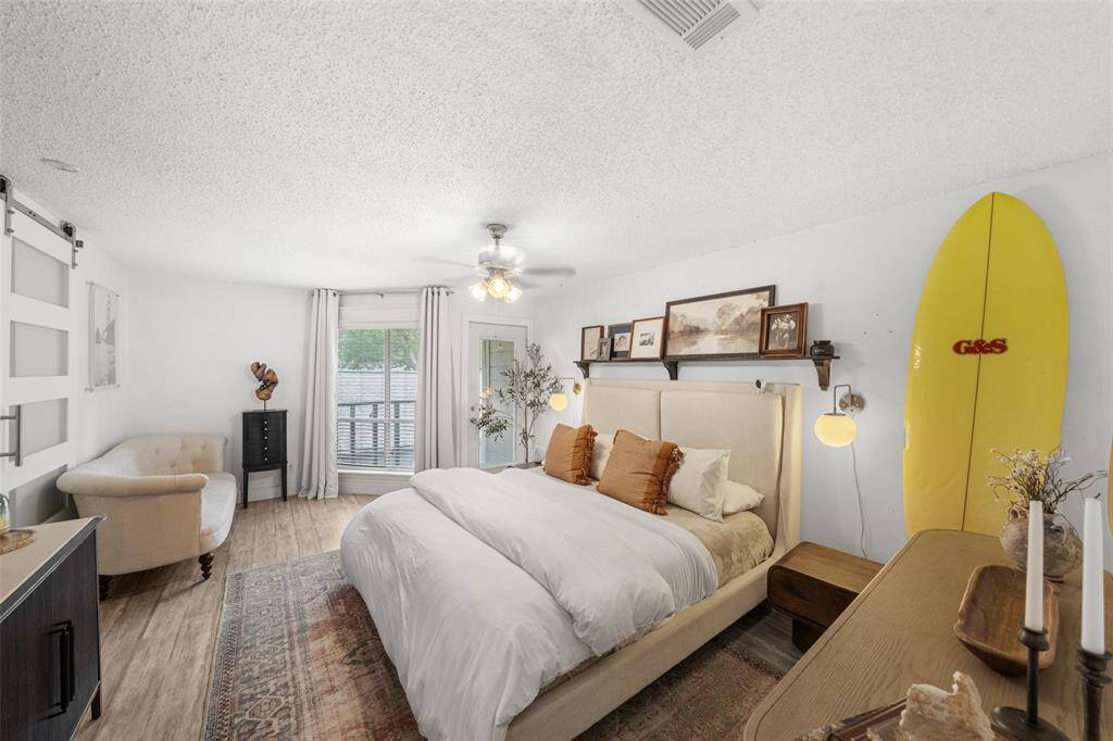 This bright and cozy bedroom features a modern design . It has ample natural light, a ceiling fan,   creating a welcoming atmosphere.