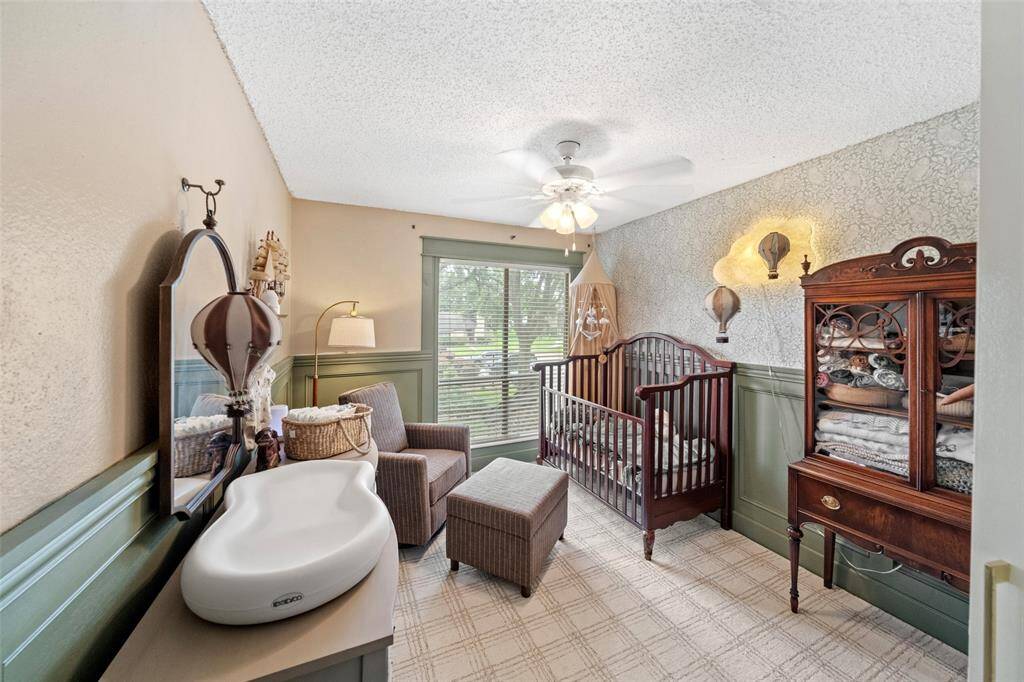 Second bedroom Features soft lighting, a ceiling fan, and a large window for natural light.