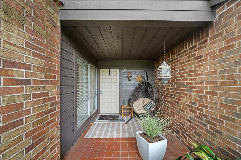 Charming covered entryway with a brick and wood exterior, featuring a welcoming entry.