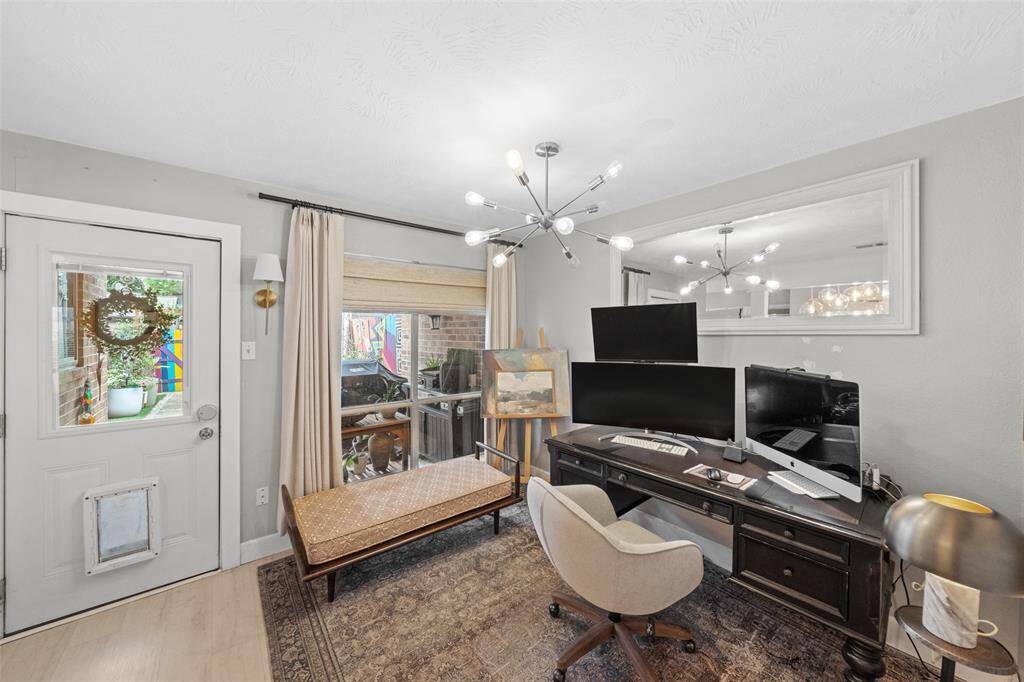 This photo showcases a cozy home office with a modern chandelier.