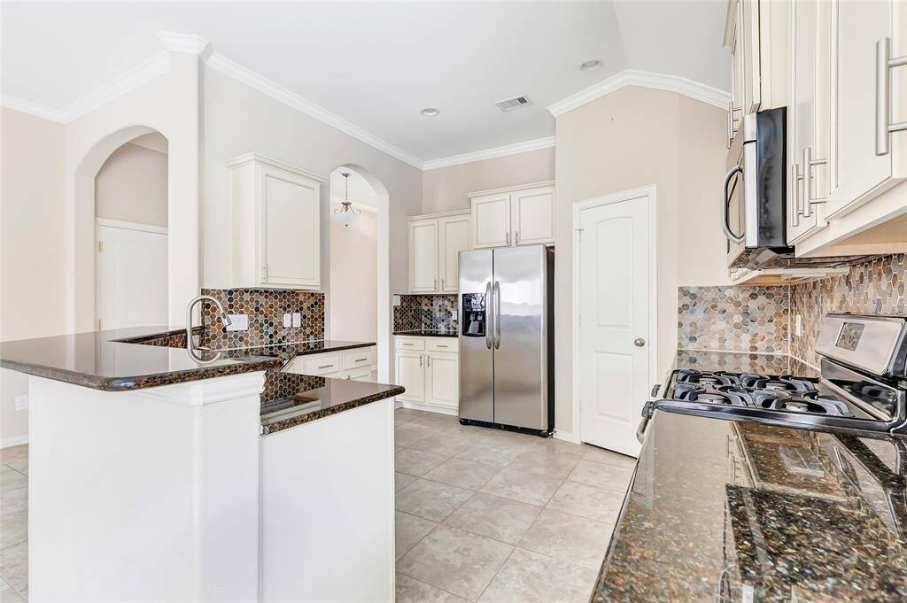 Breakfast bar for additional seating, granite counters, tile backsplash and walk in pantry. The refrigerator is also included PLUS there is another refrigerator in the garage for drinks that stays!