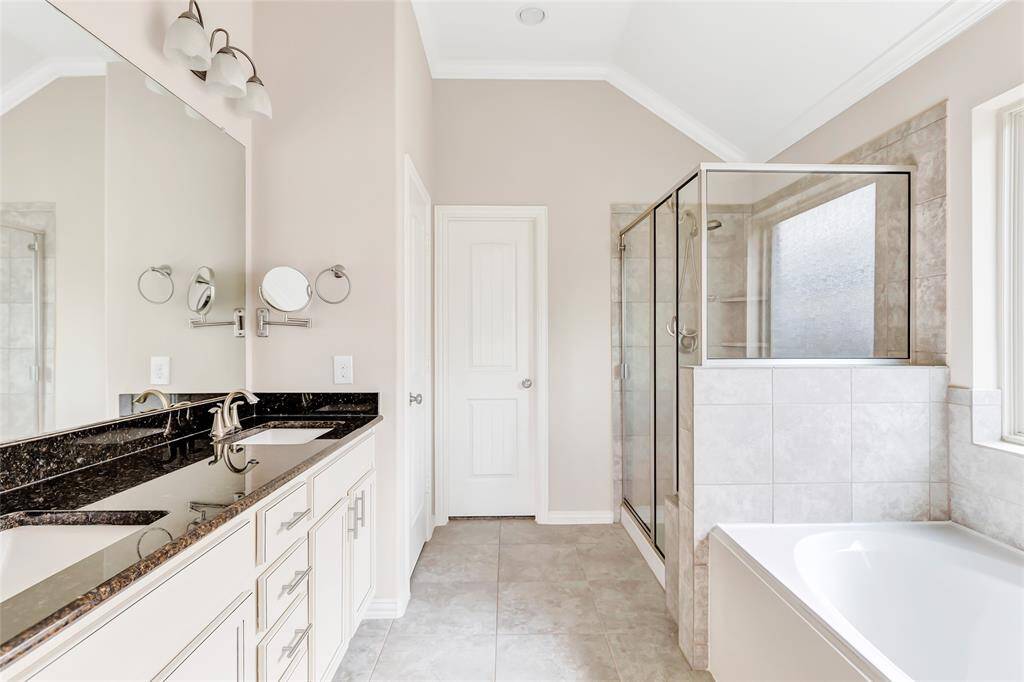 Owner's spa-like bath has it all! double sinks (no sharing here!) granite counter, drawers, soaking tub and oversized shower with seat plus walk in closet.
