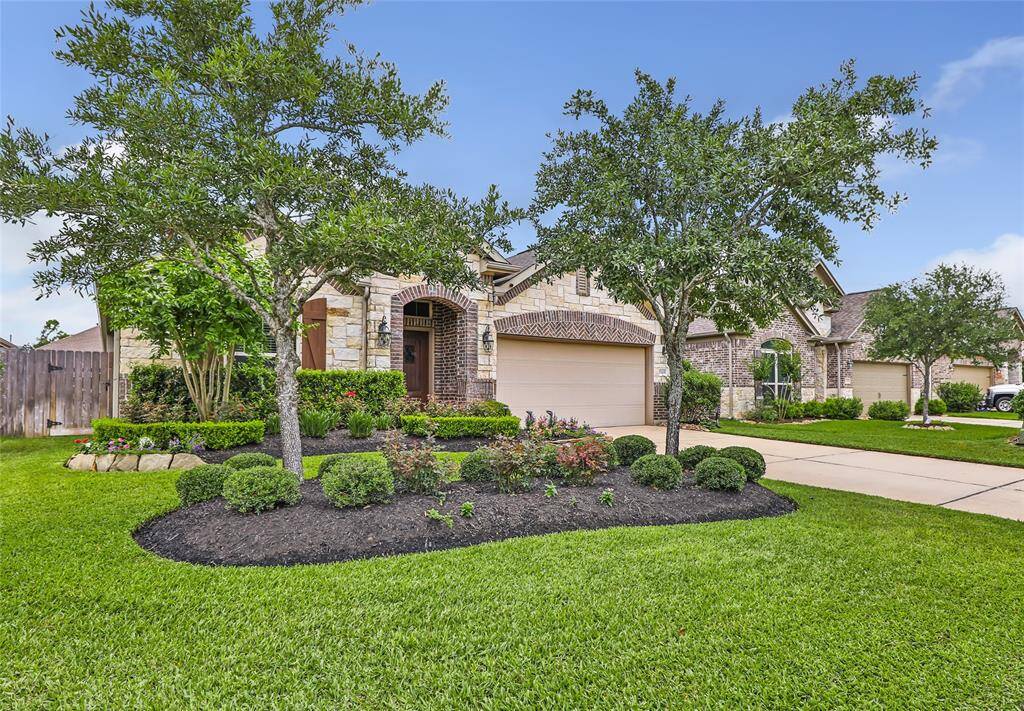 Love the brick and stone accents on the front plus the wooden shutters -- WOW THIS YARD!