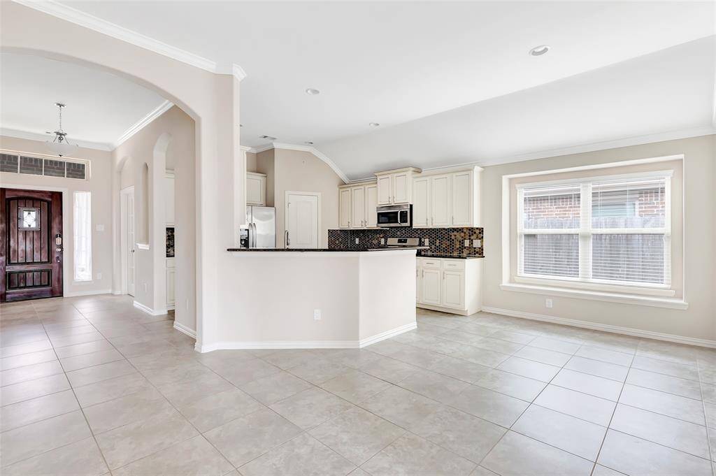Kitchen view from the family room. Tile flooring throughout home makes maintaining easy.  Light and bright with fresh interior paint.
