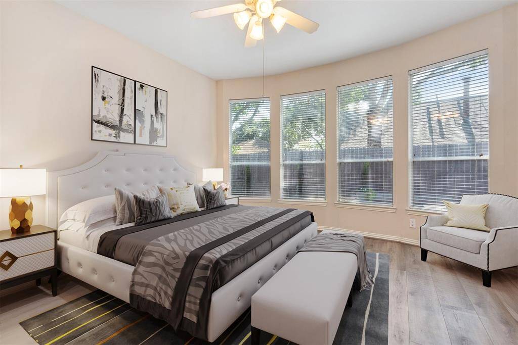 Virtual photo of primary bedroom. Room is nice and sunny with the wall of windows.