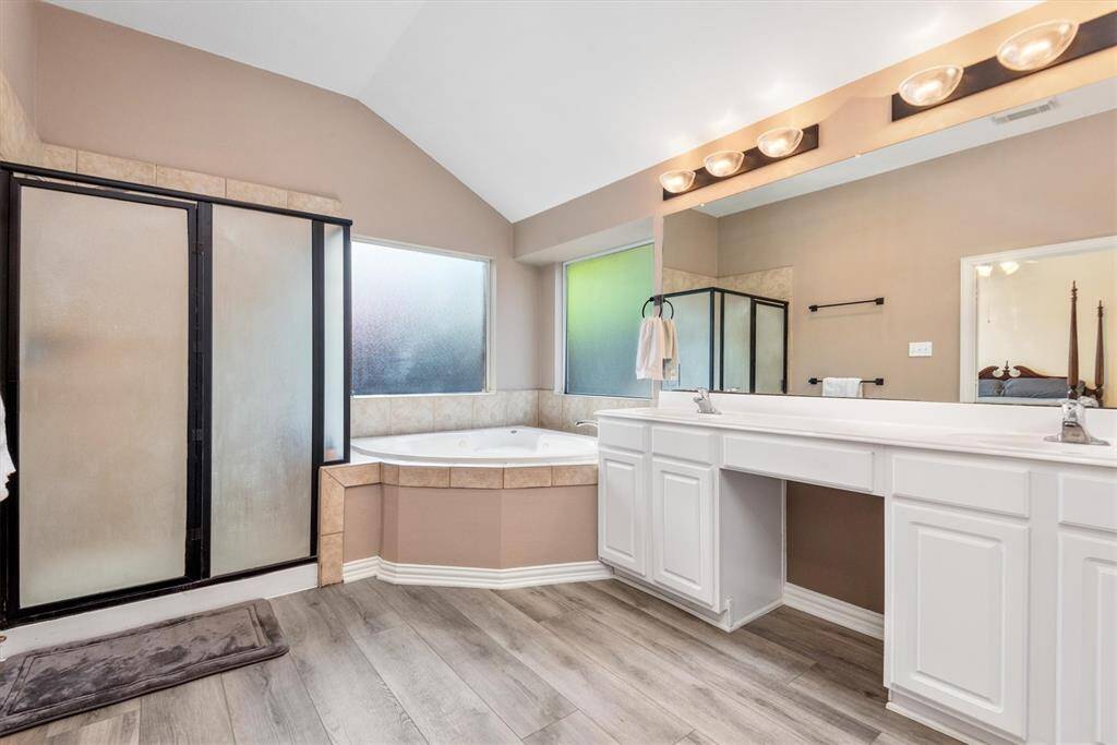 Primary en-suite bathroom with jetted tub, separate shower and two vanities.