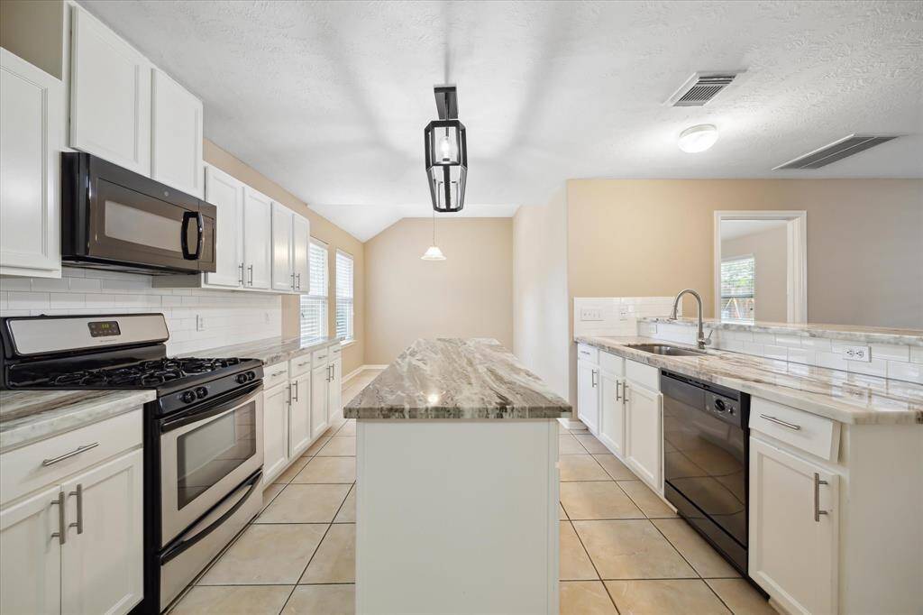Experience the elegance of a fully remodeled kitchen featuring marbled granite countertops, a spacious island, and a cozy breakfast nook.