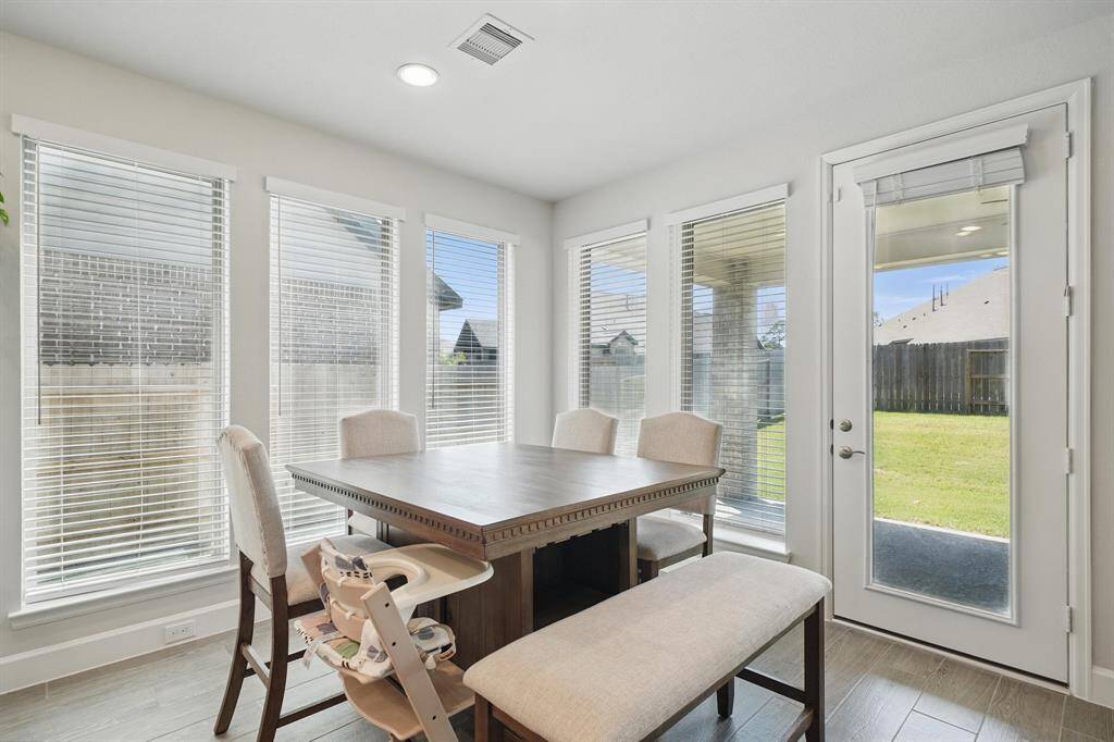 Surrounded by windows, the breakfast nook offers a bright and airy spot to enjoy meals with direct access to the backyard and covered patio.