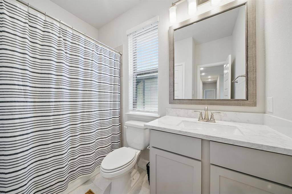 An upstairs bath features a tub/shower combo, framed mirror, and modern finishes, conveniently located for secondary bedrooms and guest use.