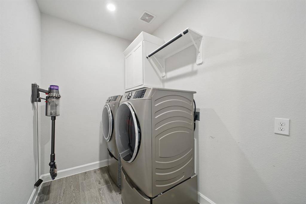 Spacious laundry room with upper cabinetry and room for additional storage or folding space—designed with functionality in mind.