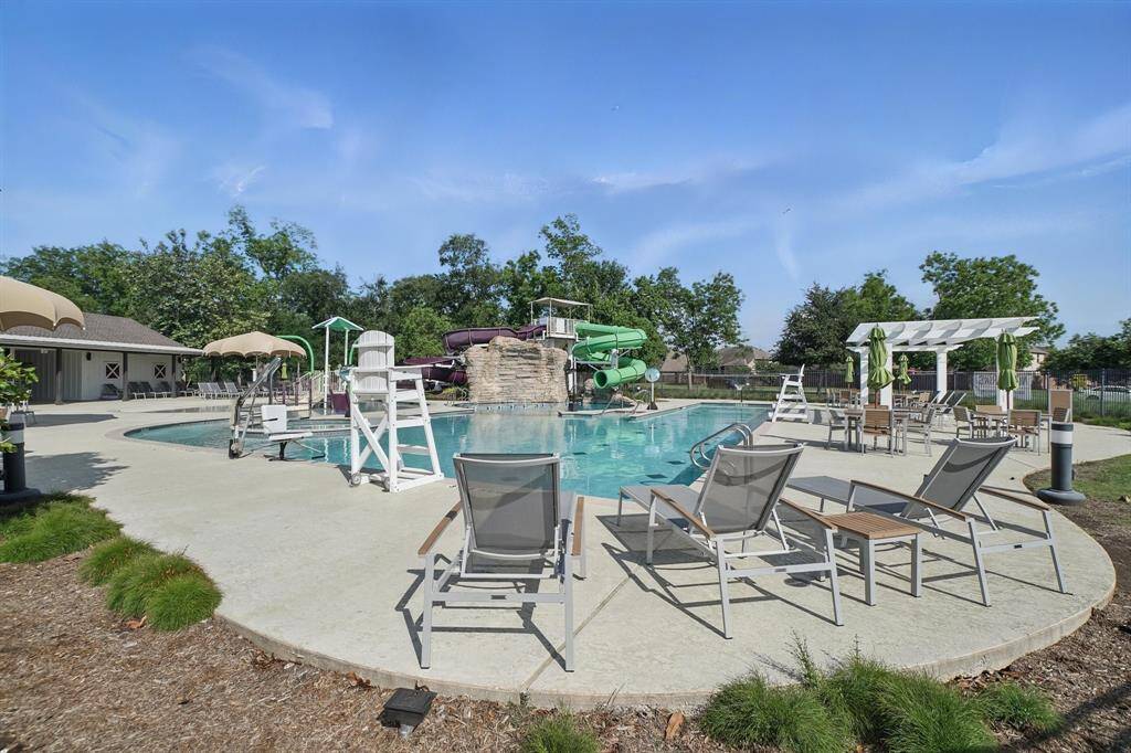 Resort-style pool area features multiple water slides, shaded lounging areas, and ample seating—perfect for cooling off and relaxing with family and friends.