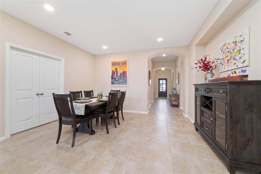 Open concept dining room with the home office/study behind the double doors.