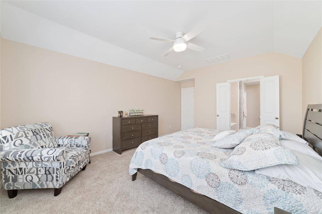 Primary bedroom suite with double sinks, soaking tub, separate shower, and large walk-in closet.