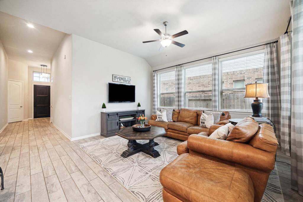 Bright and spacious living room with high ceilings, featuring large windows, wood-style flooring, and fresh neutral finishes. The perfect space to relax and unwind.