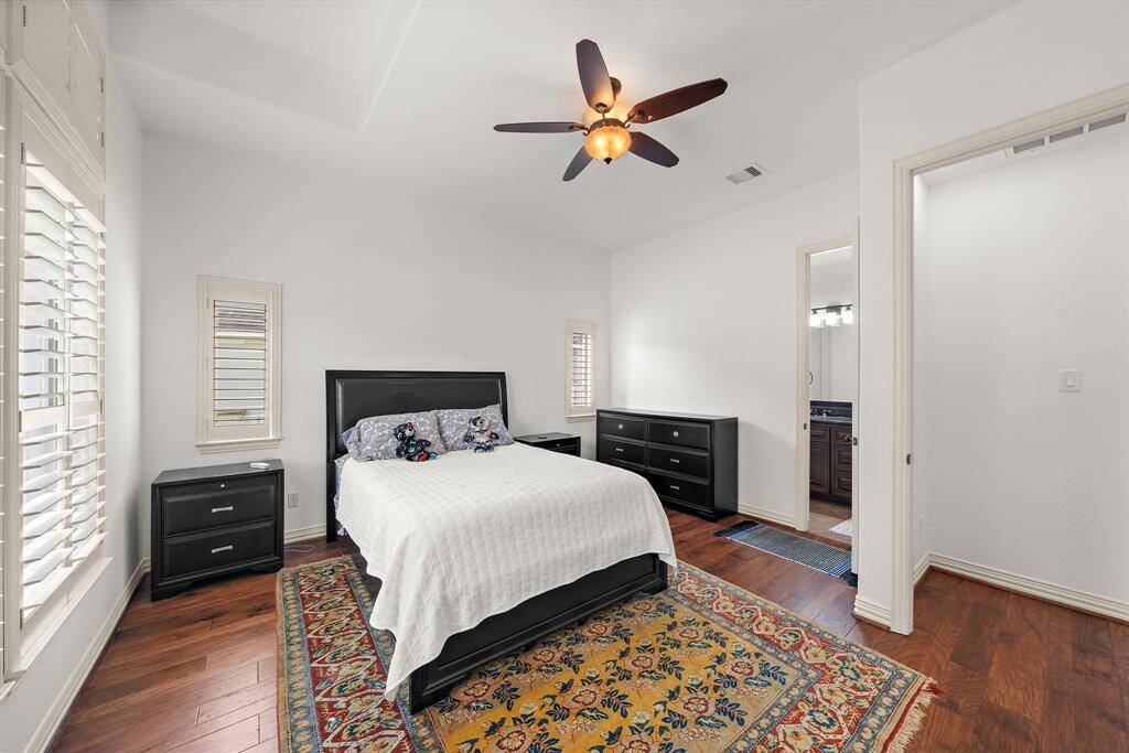 Secondary bedroom on the first floor has gorgeous plantation shutters and soaring ceilings.