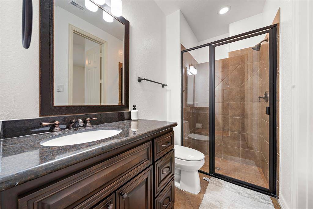 Spacious secondary bathroom with upgraded lighting.