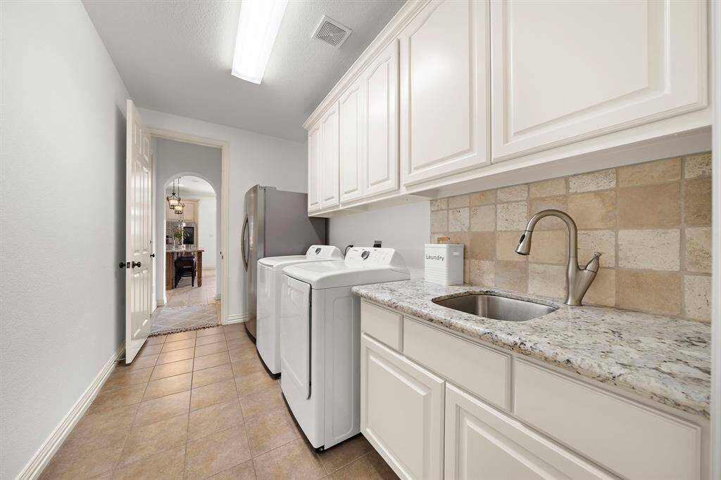 The large laundry room has a sink, space for a washer and dryer AND a full sized refrigerator eliminating the need to have an extra fridge in the garage.