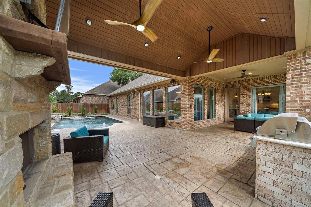 Luxury Minka Aire ceiling fans that are wifi compatible coordinate with the wood panel ceiling. In-ceiling speakers continue to the outdoor area for a seamless musical experience.