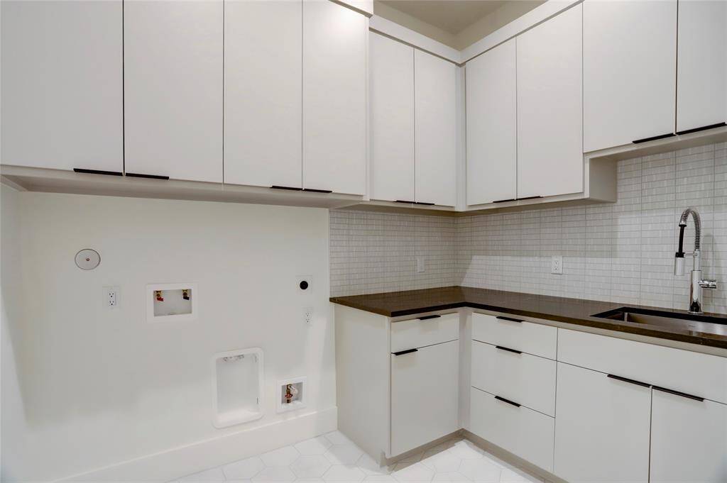 The main utility room is located between the second floor bedrooms and offers plenty of cabinet and counter space with a sink.