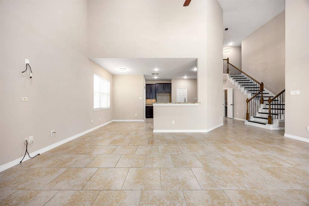 Another view of the living room space looking toward the kitchen and stairway leading to three secondary bedrooms upstairs.