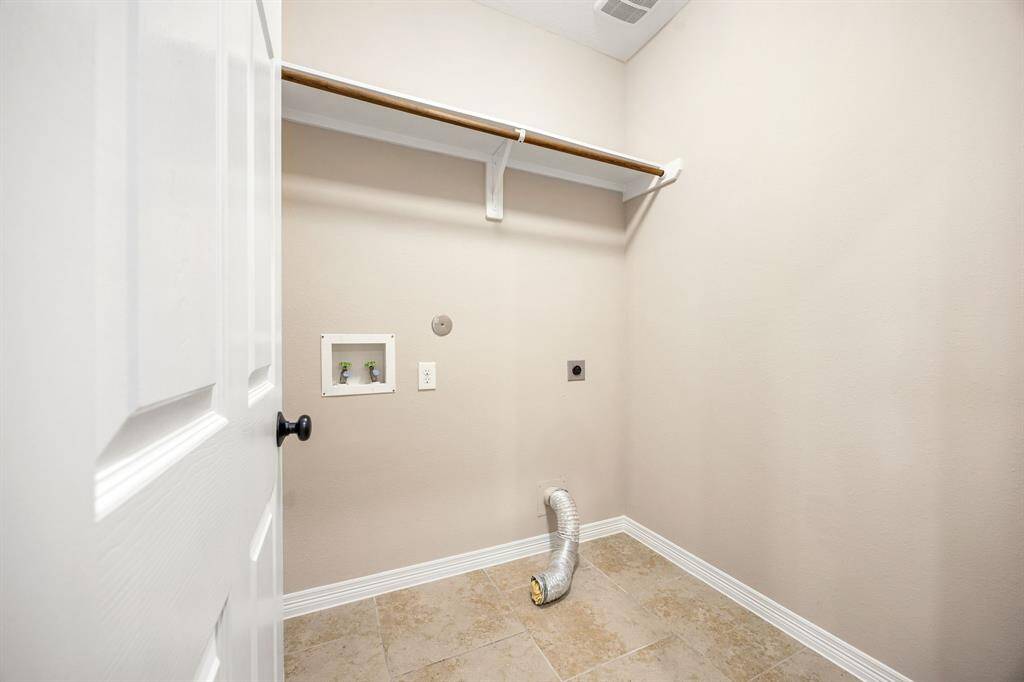 Conveniently located just off the kitchen, the laundry room offers easy access and added functionality for daily chores.