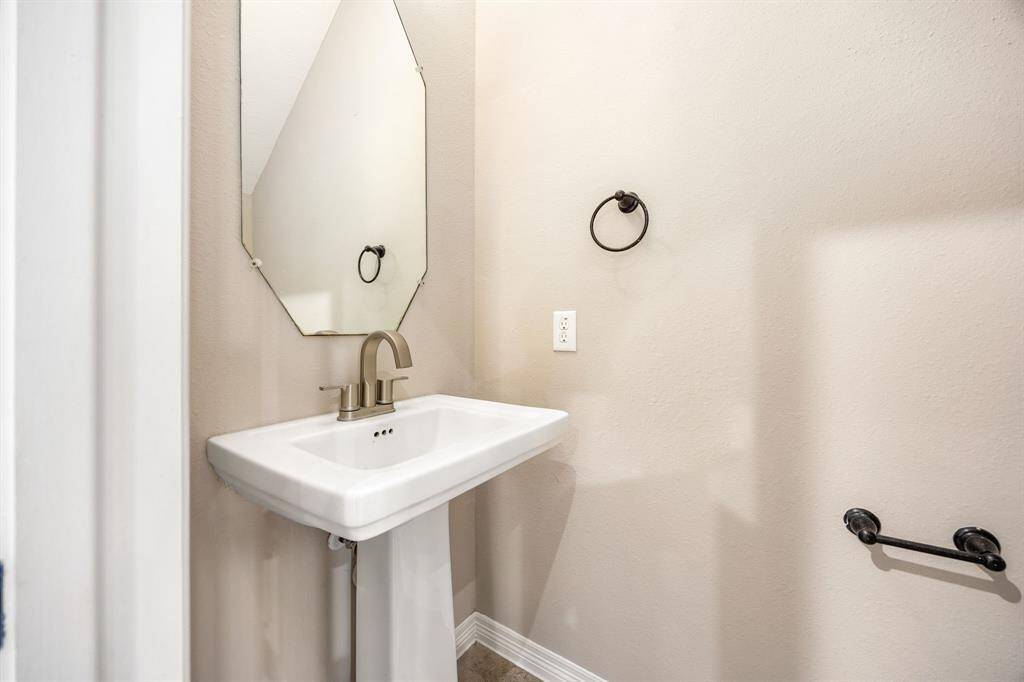 A conveniently placed half bath is tucked beneath the stairway, offering easy access for guests while maximizing space efficiency.