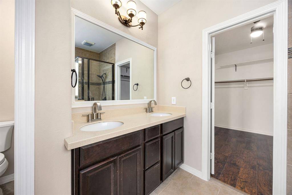 Primary bathroom has dual sinks and a large walk-in closet.