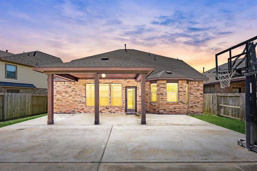 An extended back patio with an additional concrete slab, currently used for basketball, offers endless possibilities. The extra concrete can be removed to make space for a pool or transformed with a stamped concrete overlay—it's a blank canvas for your outdoor vision.